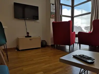 a living room with two chairs and a flat screen tv at Apartman D11 Dvori in Kopaonik