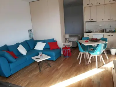 a living room with a blue couch and a table at Apartman D11 Dvori in Kopaonik