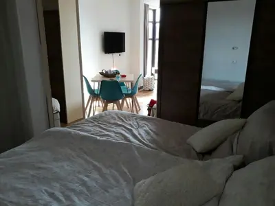 a bedroom with a bed and a table and a mirror at Apartman D11 Dvori in Kopaonik