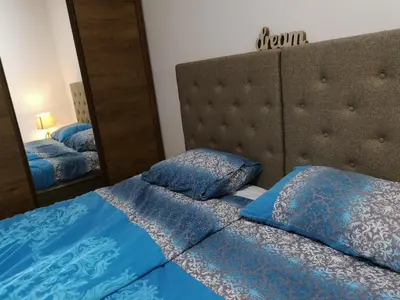 a bedroom with a bed and a large mirror at Apartman D11 Dvori in Kopaonik