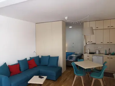 a living room with a blue couch and a table at Apartman D11 Dvori in Kopaonik