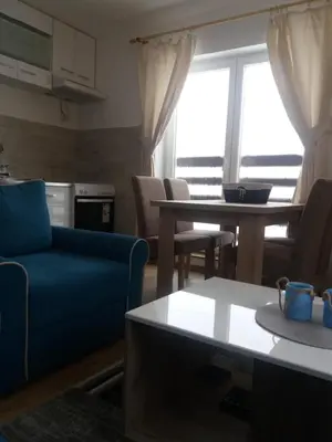 a living room with a blue couch and a table at Apartman Jana do Kraljevih cardaka in Kopaonik