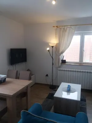 a living room with a blue couch and a table at Apartman Jana do Kraljevih cardaka in Kopaonik
