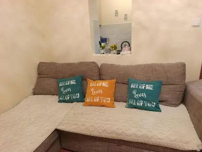 a brown couch with three pillows on it at Ljubica in Brzeće