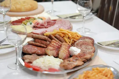 a plate of sausage and french fries on a table at BAJKA in Crni Vrh