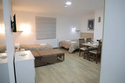 a room with two beds and a table and chairs at BAJKA in Crni Vrh