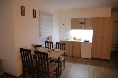 a kitchen and dining room with a table and chairs at BAJKA in Crni Vrh