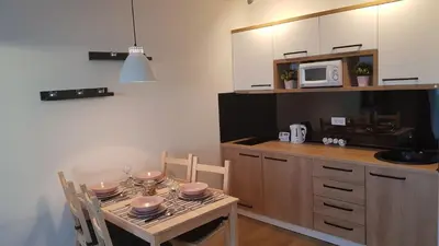 a kitchen with a table with chairs and a microwave at Apartman Jovanovic Kopaonik in Kopaonik