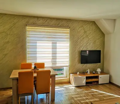 a dining room with a table and a television at Iznad Oblaka Apartman 8 in Kopaonik