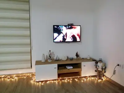 a living room with a tv on a wall with lights at Iznad Oblaka Apartman 8 in Kopaonik