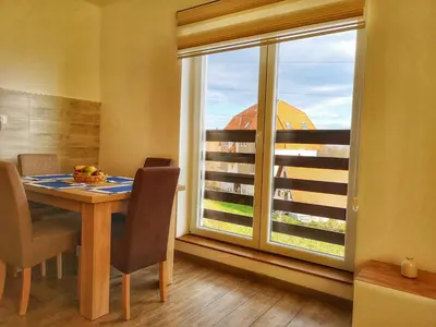 a dining room with a table and a large window at Iznad Oblaka Apartman 8 in Kopaonik