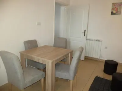 a dining room table with chairs and a wooden table at Apartments 1A JollyKop in Kopaonik