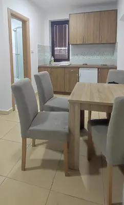 a kitchen with a wooden table and two chairs at Apartments 1A JollyKop in Kopaonik
