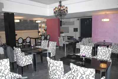 a restaurant with black and white chairs and tables at B&B Rose in Vranje