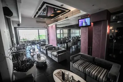 a restaurant with couches and tables and a television at B&B Rose in Vranje
