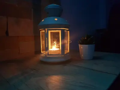 a candle in a lantern sitting on a table in the dark at Milmari RELAX apartment in Kopaonik
