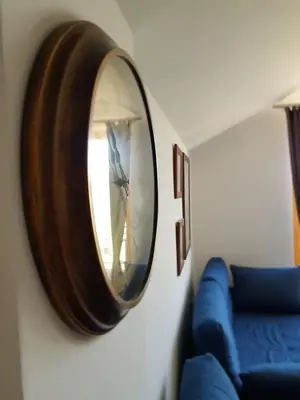a mirror hanging on a wall next to a blue couch at Milmari RELAX apartment in Kopaonik