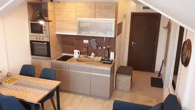 a small kitchen with a table and a dining room at Milmari RELAX apartment in Kopaonik