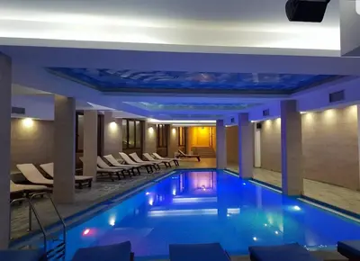 a large swimming pool in a hotel with chairs at Milmari RELAX apartment in Kopaonik