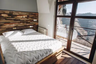 a bedroom with a large bed and a large window at Jules Verne apartments in Kopaonik