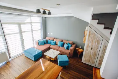 a living room with a brown couch and blue pillows at Jules Verne apartments in Kopaonik