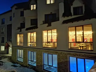 a building with illuminated windows at night with a patio at Milmari L44 in Kopaonik
