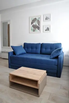 a blue couch in a living room with a coffee table at Milmari L44 in Kopaonik
