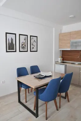 a dining room table and blue chairs in a kitchen at Milmari L44 in Kopaonik