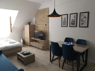 a living room with a table and chairs and a living room at Milmari L44 in Kopaonik