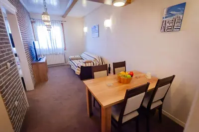 a dining room with a wooden table and chairs at Top Lux Zupa in Kopaonik