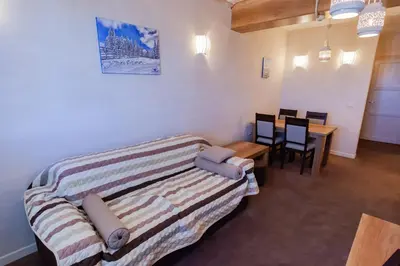 a room with a bed and a table and chairs at Top Lux Zupa in Kopaonik