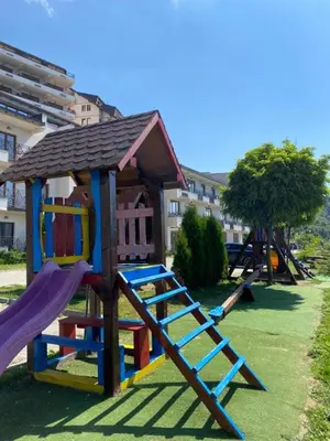 a playground with a slide and a play structure at Privat Studio Milmari in Kopaonik