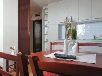 a table with a remote control and a vase on it at Apartment Lavina Kopaonik in Kopaonik