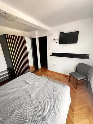 a bedroom with a bed and a tv on the wall at Guest House Vila Pobeda in Vrnjačka Banja