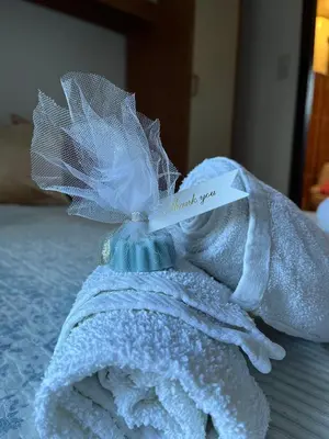 a white towel with a piece of paper on it at Guest House Vila Pobeda in Vrnjačka Banja