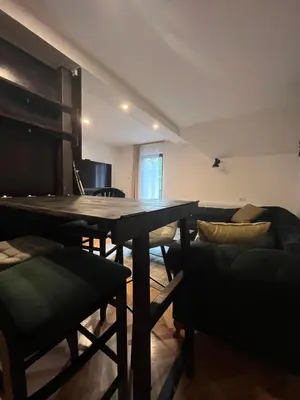 a living room with a wooden table and chairs at Guest House Vila Pobeda in Vrnjačka Banja