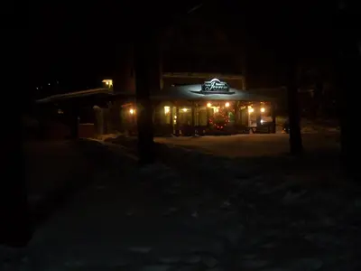 a building with a lit up sign at night at Guest House Vila Pobeda in Vrnjačka Banja