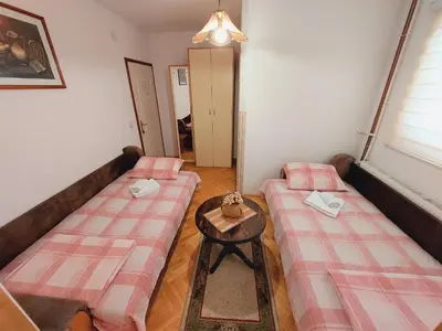 a living room with two beds and a table at Apartments Nikolić in Soko Banja