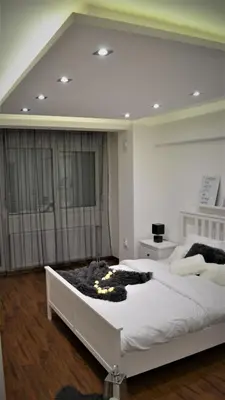 a bedroom with two white beds and a window at NEW Center Apartments in Niš
