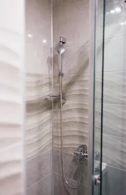a shower in a bathroom with a glass door at NEW Center Apartments in Niš