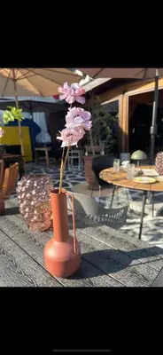 an orange vase with a pink flower in it at Villa Grazia in Vladičin Han