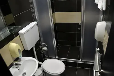a bathroom with a toilet and a sink and a shower at Hotel Golf in Kruševac