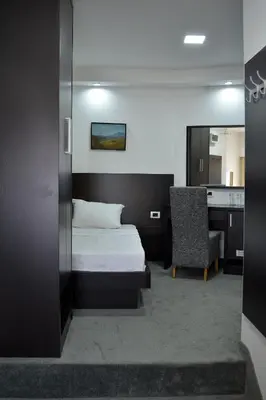 a bedroom with a bed and a desk and a chair at Hotel Golf in Kruševac