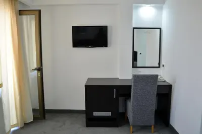 a desk with a television and a chair in a room at Hotel Golf in Kruševac
