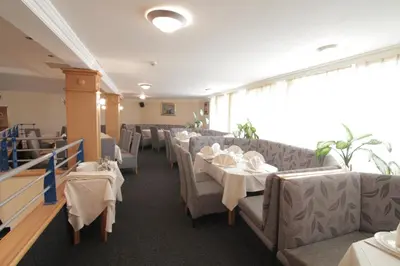 a dining room with tables and chairs with white table linen at Hotel Golf in Kruševac