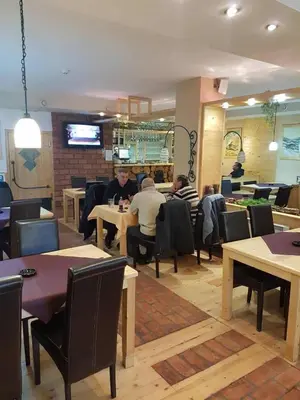 a group of people sitting at tables in a restaurant at Apartman-Vila Nikola, 064jedansedamdvatridevetnulatri in Kopaonik