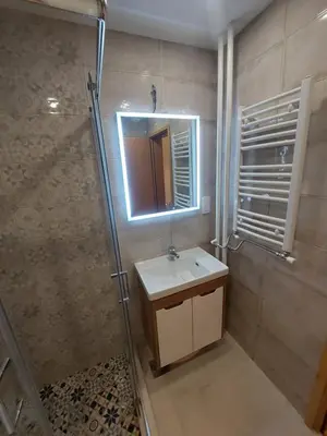 a bathroom with a sink and a shower with a mirror at Apartman-Vila Nikola, 064jedansedamdvatridevetnulatri in Kopaonik