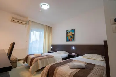 a hotel room with two beds and a window at Hotel Golf Luxury in Kruševac