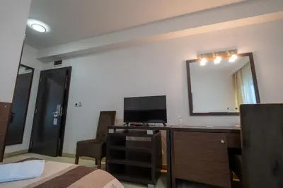 a bedroom with a desk with a television and a mirror at Hotel Golf Luxury in Kruševac