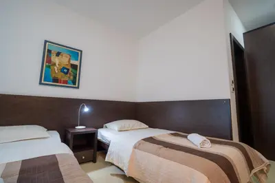 a hotel room with two beds and a picture on the wall at Hotel Golf Luxury in Kruševac